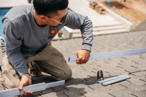 Solar installer assembling rooftop solar panel mounting system